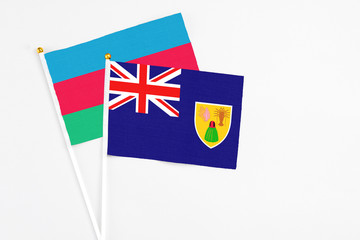 Fototapeta premium Turks And Caicos Islands and Azerbaijan stick flags on white background. High quality fabric, miniature national flag. Peaceful global concept.White floor for copy space.