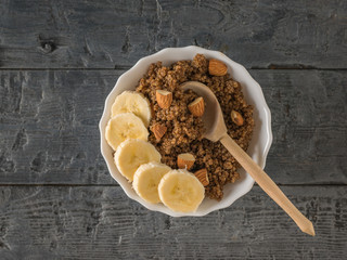 Fototapeta premium Wooden spoon in a Cup of quinoa porridge. Flat lay.