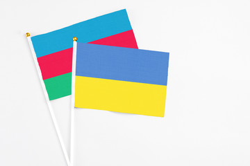 Ukraine and Azerbaijan stick flags on white background. High quality fabric, miniature national flag. Peaceful global concept.White floor for copy space.
