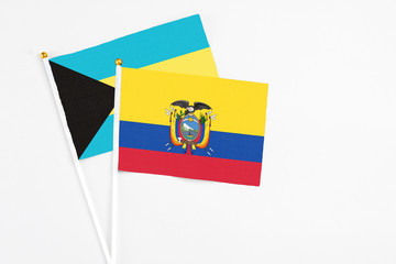 Ecuador and Bahamas stick flags on white background. High quality fabric, miniature national flag. Peaceful global concept.White floor for copy space.