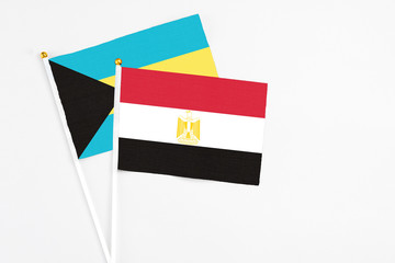 Egypt and Bahamas stick flags on white background. High quality fabric, miniature national flag. Peaceful global concept.White floor for copy space.