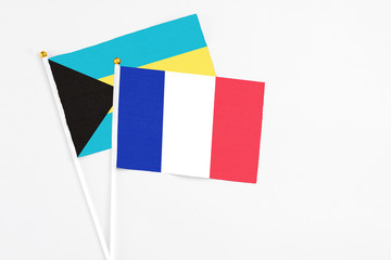 France and Bahamas stick flags on white background. High quality fabric, miniature national flag. Peaceful global concept.White floor for copy space.