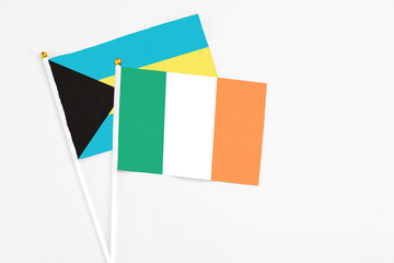 Ireland and Bahamas stick flags on white background. High quality fabric, miniature national flag. Peaceful global concept.White floor for copy space.