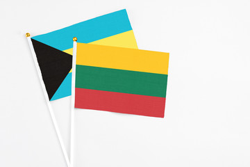 Lithuania and Bahamas stick flags on white background. High quality fabric, miniature national flag. Peaceful global concept.White floor for copy space.