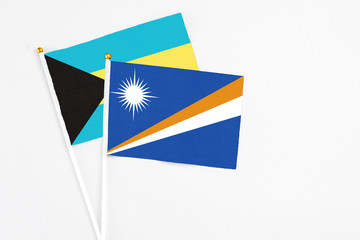 Marshall Islands and Bahamas stick flags on white background. High quality fabric, miniature national flag. Peaceful global concept.White floor for copy space.