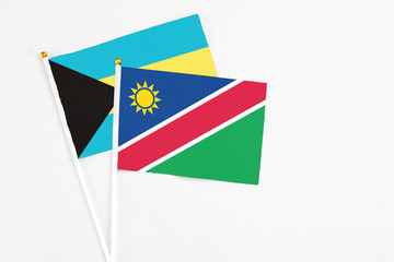 Namibia and Bahamas stick flags on white background. High quality fabric, miniature national flag. Peaceful global concept.White floor for copy space.
