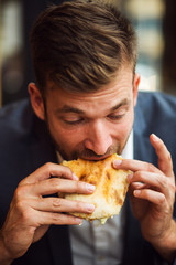 Businessman eating junk food sandwich 