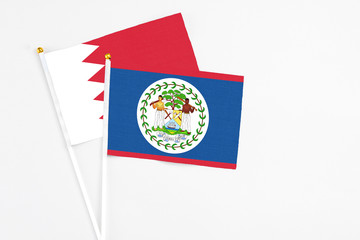 Belize and Bahrain stick flags on white background. High quality fabric, miniature national flag. Peaceful global concept.White floor for copy space.