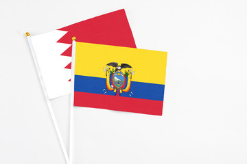 Ecuador and Bahrain stick flags on white background. High quality fabric, miniature national flag. Peaceful global concept.White floor for copy space.