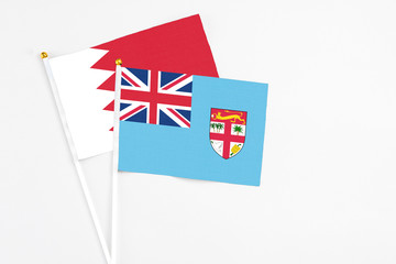 Fiji and Bahrain stick flags on white background. High quality fabric, miniature national flag....