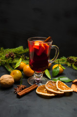 Christmas mulled wine with spices and oranges and tangerines on a wooden rustic table. Traditional hot drink for Christmas. Selective focus.