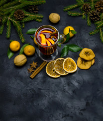 Christmas mulled wine with spices and oranges and tangerines on a wooden rustic table. Traditional hot drink for Christmas. Selective focus.