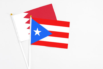 Puerto Rico and Bahrain stick flags on white background. High quality fabric, miniature national flag. Peaceful global concept.White floor for copy space.
