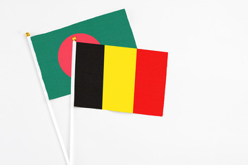Belgium and Bangladesh stick flags on white background. High quality fabric, miniature national flag. Peaceful global concept.White floor for copy space.