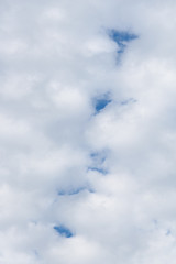 Small puffy white cloud pattern with glimpses of blue sky as a nature background