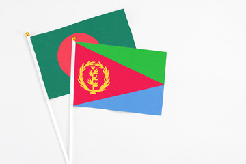 Eritrea and Bangladesh stick flags on white background. High quality fabric, miniature national flag. Peaceful global concept.White floor for copy space.