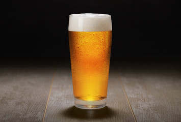 A fresh pint of India Pale ale IPA craft beer served in a cold pint glass at a brewery, black...