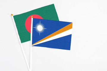 Marshall Islands and Bangladesh stick flags on white background. High quality fabric, miniature...