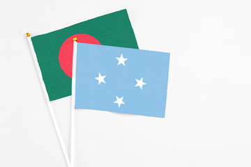 Micronesia and Bangladesh stick flags on white background. High quality fabric, miniature national flag. Peaceful global concept.White floor for copy space.