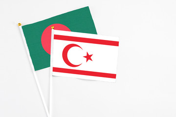 Northern Cyprus and Bangladesh stick flags on white background. High quality fabric, miniature national flag. Peaceful global concept.White floor for copy space.