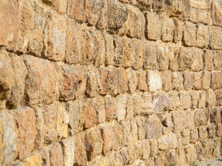 Pattern of sandy stonewall, abstract background, close up view. Structure of stonewall. Selective soft focus. Blurred background