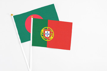 Portugal and Bangladesh stick flags on white background. High quality fabric, miniature national flag. Peaceful global concept.White floor for copy space.