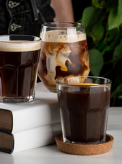 Milk is swirling and splashing in a glass of iced latte