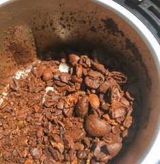 Macro photo of freshly ground coffee in an electric coffee grinder.