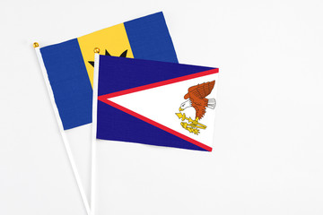 American Samoa and Barbados stick flags on white background. High quality fabric, miniature national flag. Peaceful global concept.White floor for copy space.