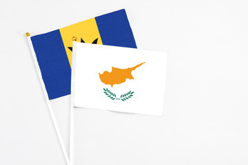 Cyprus and Barbados stick flags on white background. High quality fabric, miniature national flag. Peaceful global concept.White floor for copy space.