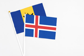 Obraz premium Iceland and Barbados stick flags on white background. High quality fabric, miniature national flag. Peaceful global concept.White floor for copy space.