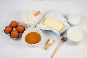 Fototapeta na wymiar The ingredients for the honey cake are laid out on a white table in the middle. Horizontal orientation.