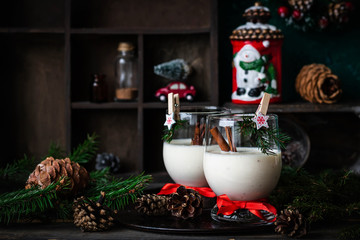 Traditional eggnog Christmas cocktail in a glass goblet decorated with New Year clothespin. Non-alcoholic option.