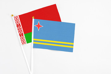 Aruba and Belarus stick flags on white background. High quality fabric, miniature national flag. Peaceful global concept.White floor for copy space.