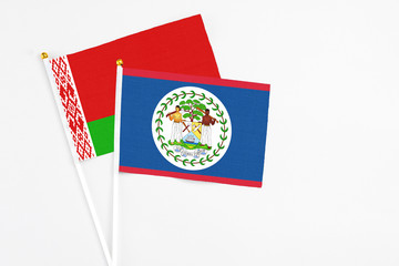 Belize and Belarus stick flags on white background. High quality fabric, miniature national flag. Peaceful global concept.White floor for copy space.