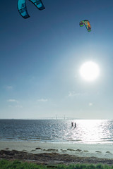 Kite surfing in the sea with the bridge over sea in background.