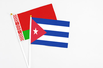 Cuba and Belarus stick flags on white background. High quality fabric, miniature national flag. Peaceful global concept.White floor for copy space.