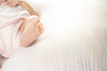 Obraz na płótnie Canvas Newborn baby feet on a white blanket - tiny baby feet closeup