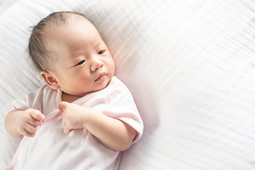 Happy Adorable baby girl sleeping in crib. Small kid having day nap in parents bed