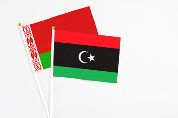 Libya and Belarus stick flags on white background. High quality fabric, miniature national flag. Peaceful global concept.White floor for copy space.