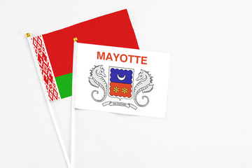 Mayotte and Belarus stick flags on white background. High quality fabric, miniature national flag. Peaceful global concept.White floor for copy space.