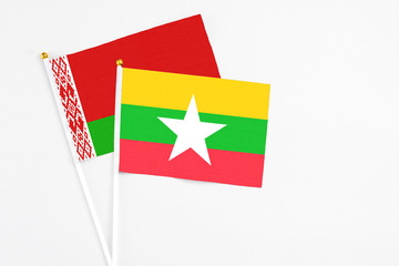 Myanmar and Belarus stick flags on white background. High quality fabric, miniature national flag. Peaceful global concept.White floor for copy space.