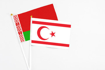 Fototapeta premium Northern Cyprus and Belarus stick flags on white background. High quality fabric, miniature national flag. Peaceful global concept.White floor for copy space.