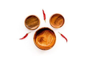 Asian cuisine concept. Wooden bowls and chili pepper on white background top view copy space