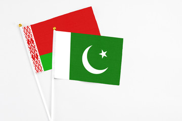 Pakistan and Belarus stick flags on white background. High quality fabric, miniature national flag. Peaceful global concept.White floor for copy space.