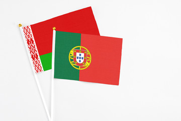 Portugal and Belarus stick flags on white background. High quality fabric, miniature national flag. Peaceful global concept.White floor for copy space.