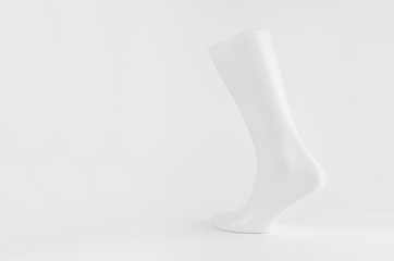 White male mannequin leg side view on white background with copy space, simple modern style layout...