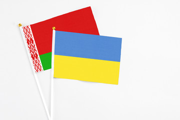 Ukraine and Belarus stick flags on white background. High quality fabric, miniature national flag. Peaceful global concept.White floor for copy space.