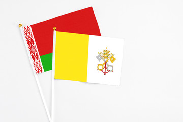 Vatican City and Belarus stick flags on white background. High quality fabric, miniature national flag. Peaceful global concept.White floor for copy space.