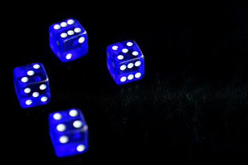 Blue dice scattered on a black surface close-up. Gambling background